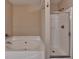 Bathroom area with separate soaking tub and shower stall with glass doors at 1749 Coleville Oak Ln, Lawrenceville, GA 30046