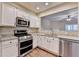 Well-equipped kitchen with stainless steel appliances and granite countertops, open to the living area at 1749 Coleville Oak Ln, Lawrenceville, GA 30046