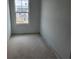Clean empty bedroom with light gray walls and natural light from the large window at 2096 Boxwood Cir, Conyers, GA 30094