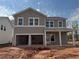 New home with two-car garage, porch, and neutral-tone siding against a partly cloudy sky at 2096 Boxwood Cir, Conyers, GA 30094