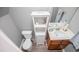 Cozy bathroom featuring a toilet, sink, wood-look flooring, and a linen closet for added storage at 207 Meadow Lake Dr, Carrollton, GA 30116