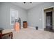 Well-lit room with plush carpet, large window, and neutral paint colors at 207 Meadow Lake Dr, Carrollton, GA 30116