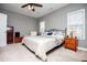 Spacious primary bedroom features neutral walls, carpet, ceiling fan and a king sized bed at 207 Meadow Lake Dr, Carrollton, GA 30116