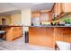Kitchen island with dark granite counters and light wood cabinets, and view into eat in space and stainless steel appliances at 207 Meadow Lake Dr, Carrollton, GA 30116