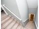 Carpeted staircase descending to lower level with white handrails and gray walls at 207 Meadow Lake Dr, Carrollton, GA 30116