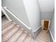 View of stairs going down, featuring carpeted steps and white railings against gray walls at 207 Meadow Lake Dr, Carrollton, GA 30116