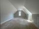Large unfinished attic space with pitched ceilings, perfect for storage or future expansion with a window at 1698 Cunningham Sw Rd, Marietta, GA 30008