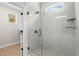 A modern bathroom features a glass shower with marble-style walls, and a view into a closet at 1698 Cunningham Sw Rd, Marietta, GA 30008