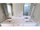 Bathroom featuring double vanity sinks with quartz countertops and framed mirrors at 1698 Cunningham Sw Rd, Marietta, GA 30008