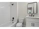 Bathroom with white subway tile in shower, matching vanity, toilet, and a modern black-framed mirror at 1698 Cunningham Sw Rd, Marietta, GA 30008