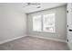 Well-lit bedroom with neutral paint and carpet, featuring a ceiling fan and a bright window at 1698 Cunningham Sw Rd, Marietta, GA 30008