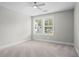 Neutral bedroom featuring a ceiling fan, a bright window and neutral colored walls and carpet at 1698 Cunningham Sw Rd, Marietta, GA 30008