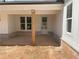View of the covered porch featuring brick accents, wooden columns, and a classic white door at 1698 Cunningham Sw Rd, Marietta, GA 30008