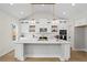 Bright kitchen boasts white cabinets, a large island with pendant lighting, and modern stainless steel appliances at 1698 Cunningham Sw Rd, Marietta, GA 30008