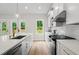 A bright kitchen offers white cabinets, stainless appliances, granite countertops, and a view to the outdoors at 1698 Cunningham Sw Rd, Marietta, GA 30008