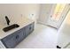 Well-lit laundry room with gray cabinets and decorative patterned flooring at 1698 Cunningham Sw Rd, Marietta, GA 30008