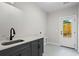 Laundry room with gray cabinets, modern sink and faucet and a patterned gray tile floor at 1698 Cunningham Sw Rd, Marietta, GA 30008