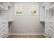 A clean, spacious walk-in closet with ample shelving, drawers, and natural light from the two windows at 1698 Cunningham Sw Rd, Marietta, GA 30008