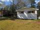 A single-story home with a white brick facade, brown shutters, and a spacious grassy yard at 3531 Creighton Sw Rd, Atlanta, GA 30331