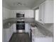 Bright kitchen with white cabinets, stainless steel appliances and granite countertops at 3531 Creighton Sw Rd, Atlanta, GA 30331