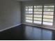 A corner living room features a white brick wall with grey laminate flooring and a large multi-pane window at 3531 Creighton Sw Rd, Atlanta, GA 30331
