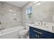 Bathroom features grey tile surround, blue vanity, and shower-tub combination at 6446 E Windsor Ln, Norcross, GA 30093