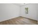 Clean and bright bedroom featuring stylish wood floors and a window for natural lighting at 6446 E Windsor Ln, Norcross, GA 30093
