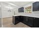 Modern kitchen with black cabinets, white marble countertops and backsplash, and stainless steel appliances at 6446 E Windsor Ln, Norcross, GA 30093