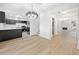 Open-concept kitchen with stainless steel appliances, black cabinets, white marble countertops, and a modern chandelier at 6446 E Windsor Ln, Norcross, GA 30093