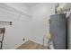 Functional laundry room featuring wood-look flooring, wire shelving, and a water heater at 6446 E Windsor Ln, Norcross, GA 30093