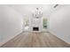 Empty living room with neutral walls, a fireplace with a marble surround, and modern light fixture at 6446 E Windsor Ln, Norcross, GA 30093