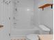 Bright bathroom with a white tub-shower combo and wooden shelf at 1506 Knights Trl, Stone Mountain, GA 30083