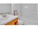 Bright bathroom featuring a woodgrain vanity and a white tiled shower and tub at 1506 Knights Trl, Stone Mountain, GA 30083