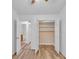 Bright bedroom closet featuring an open sliding door, custom shelving and wood grain laminate flooring at 1506 Knights Trl, Stone Mountain, GA 30083