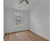 White bedroom featuring a ceiling fan, a window, and wood grain laminate flooring at 1506 Knights Trl, Stone Mountain, GA 30083