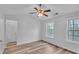 Bedroom featuring wood flooring, a fan, and two windows offering natural light at 1506 Knights Trl, Stone Mountain, GA 30083