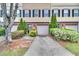 View of the townhome with single garage, concrete driveway and neatly maintained landscaping at 1506 Knights Trl, Stone Mountain, GA 30083