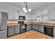 Well-lit kitchen with modern black appliances, warm wood accents, and gray and white cabinets at 1506 Knights Trl, Stone Mountain, GA 30083