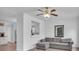 Cozy living room with gray sectional couch, ceiling fan, and open view into the kitchen at 1506 Knights Trl, Stone Mountain, GA 30083