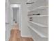 Walk-in closet with door leading to white tiled bathroom featuring custom closet shelving at 1506 Knights Trl, Stone Mountain, GA 30083