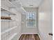 Spacious walk-in closet with white shelving, and a window for natural light at 1506 Knights Trl, Stone Mountain, GA 30083