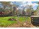 Backyard and steps leading to yellow house with lush green lawn and large trees at 1563 Mayflower Sw Ave, Atlanta, GA 30311