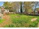 Large grassy backyard with mature trees and a partial fence at 1563 Mayflower Sw Ave, Atlanta, GA 30311
