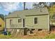 Backyard of an older home with siding and stone foundation in wooded area at 1563 Mayflower Sw Ave, Atlanta, GA 30311