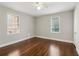 Bedroom with hardwood floors, light walls, a ceiling fan, and natural light from two windows at 1563 Mayflower Sw Ave, Atlanta, GA 30311