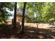 Large backyard with lush trees and greenery, featuring a wooden deck and space for recreation and outdoor activities at 1814 Oak Branch Way, Loganville, GA 30052