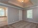 Spacious carpeted bedroom features a tray ceiling and ensuite bathroom with soaking tub, perfect for relaxation at 1814 Oak Branch Way, Loganville, GA 30052
