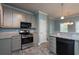 Bright kitchen featuring granite countertops, gray cabinets, black appliances, and tiled floors for a modern look at 1814 Oak Branch Way, Loganville, GA 30052