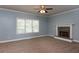 Spacious living room with plush carpet, a fireplace, and a large window providing ample natural light at 1814 Oak Branch Way, Loganville, GA 30052