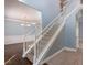 Elegant staircase featuring white railing, hardwood floors, with views of the formal dining and living areas at 1814 Oak Branch Way, Loganville, GA 30052